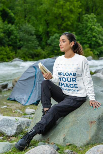 Crewneck Sweatshirt Mockup of a Woman Sitting on a Camping Site with a Book on Her Hand m35582