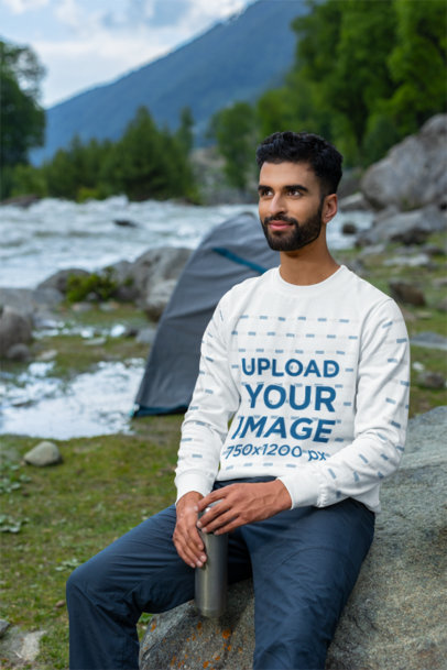 Sweatshirt Mockup Featuring a Smiling Bearded Man Sitting on a Rock
