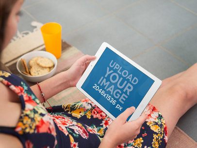 iPad Mockup of Young Woman Sitting on the Floor Using White iPad