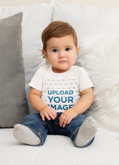 T-Shirt Mockup Featuring a Cute Baby Boy Sitting on a Couch