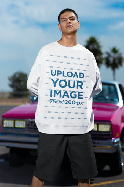 Oversized Sweatshirt Mockup Featuring a Serious Man With Tattoos Posing Against a Car