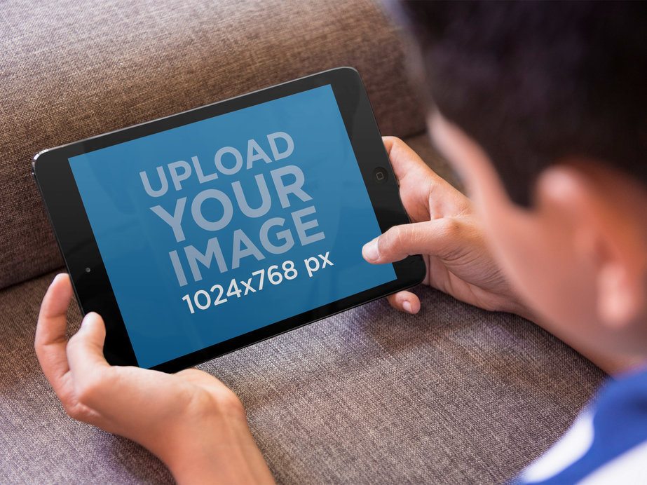 Tablet Mockup of Boy Playing With iPad Mini on the Couch