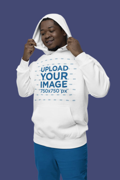 Mockup of a Happy Man Wearing a Cotton Heritage Hoodie in a Studio