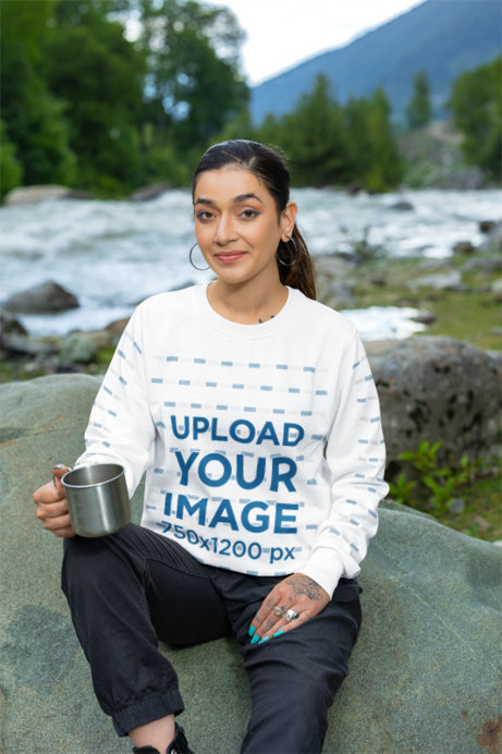 Crewneck Sweatshirt Mockup Featuring a Tattooed Woman Sitting on a Rock
