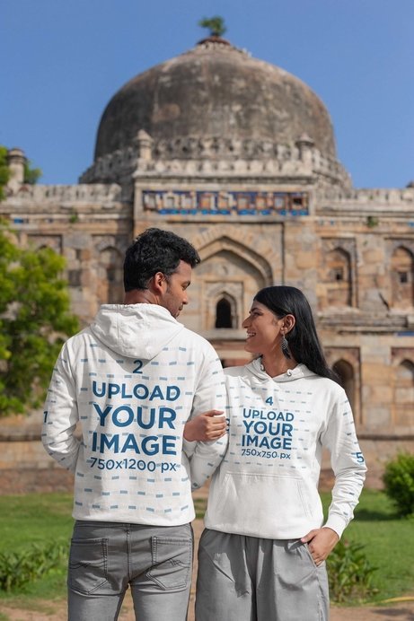 Gildan Hoodie Mockup Featuring a Cheerful Woman Posing With a Man Near a Monument