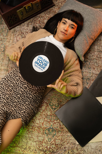 Mockup of a Woman Lying over a Vintage Rug with a Vinyl Record on Her Chest