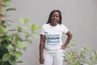 Mockup of a Senior Woman with Braids Wearing a T-Shirt Against a Concrete Wall