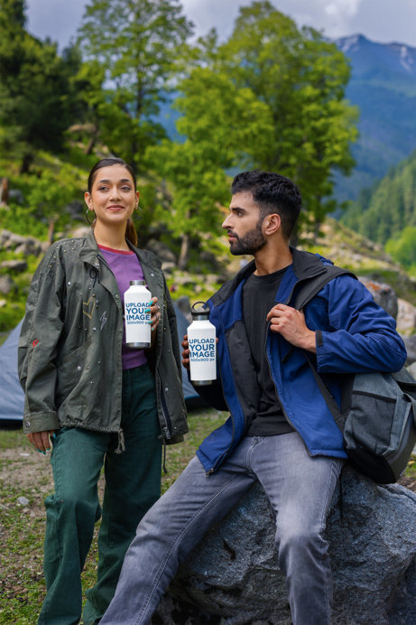 Travel Mug Mockup Featuring a Smiling Woman and a Bearded Man Posing in the Mountains