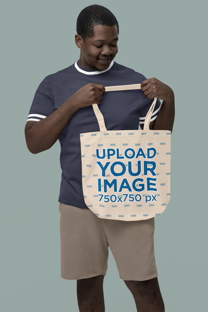 Mockup of a Man Holding a Sublimated Tote Bag from Econscious