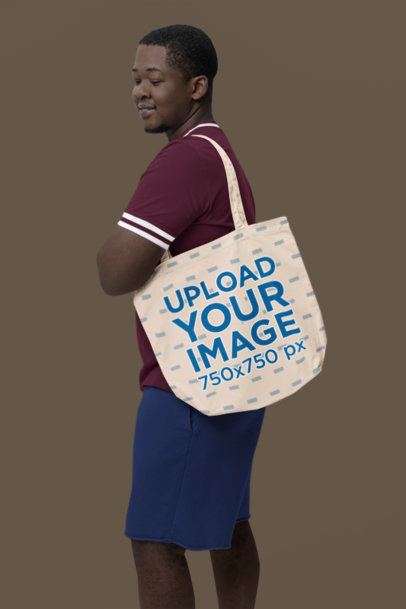 Mockup of a Man with Short Hair Carrying an Econscious Tote Bag in a Studio
