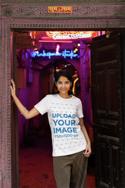 Holi Festival-Themed Scott International Tee Mockup of a Woman Standing by a Door Frame 