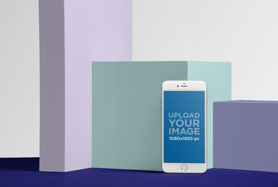 Mockup of an iPhone Standing Against 3D Shapes
