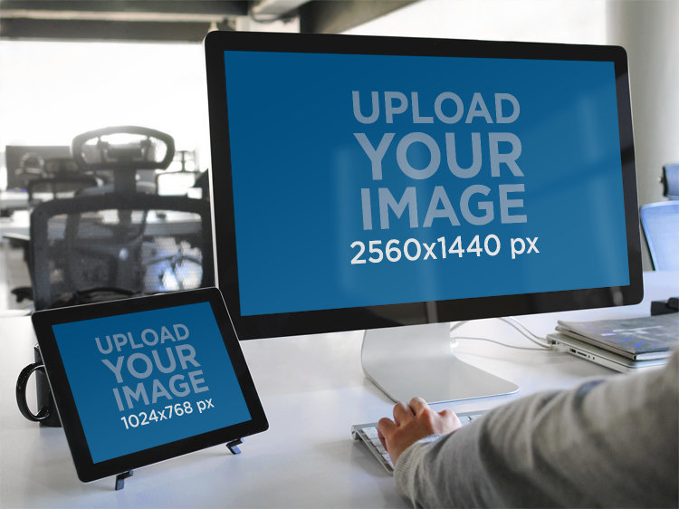 Mockup of a Man Using an iMac and an iPad at an Office