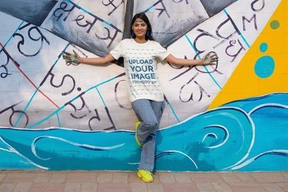 Scott International Tee Mockup of a Woman Posing in Front of a Wall Art