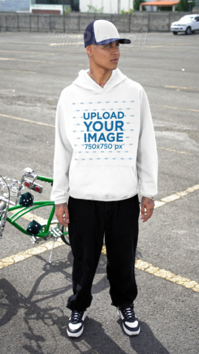 Gildan Pullover Hoodie Video Featuring a Tattooed Man Posing in a Parking Lot