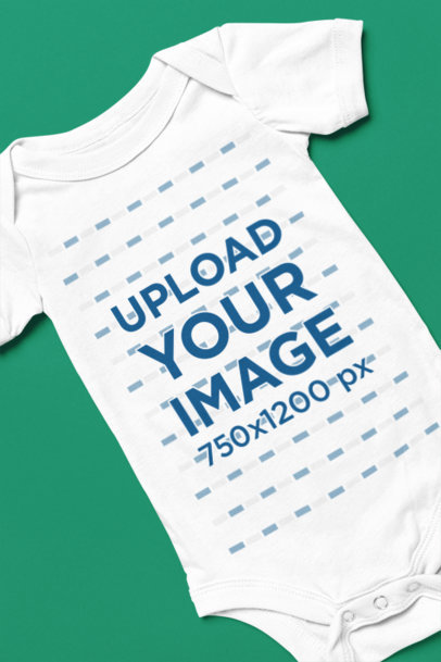 Mockup of a Bella Canvas Onesie Lying on a Customizable Background