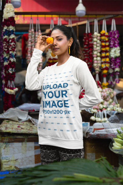 Crewneck Sweatshirt Mockup Featuring a Woman Holding a Flower Close to Her Eye