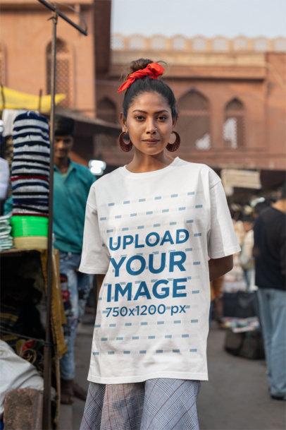 Mockup of a Woman Wearing an Oversized T-Shirt from Blinkstore at a Street Market