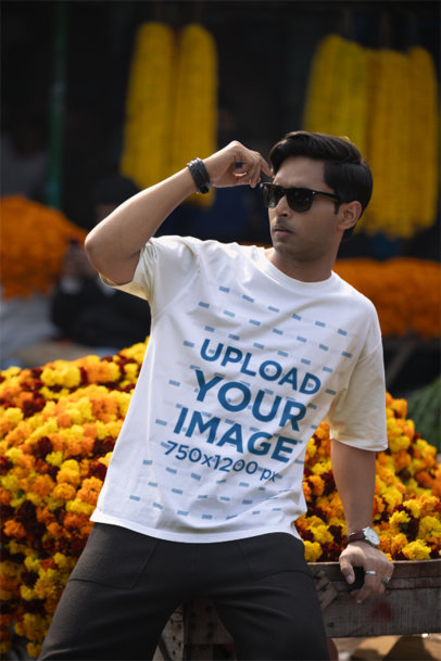 Blinkstore T-Shirt Mockup of a Cool Man Posing Against Some Flowers in a Street Market m37567