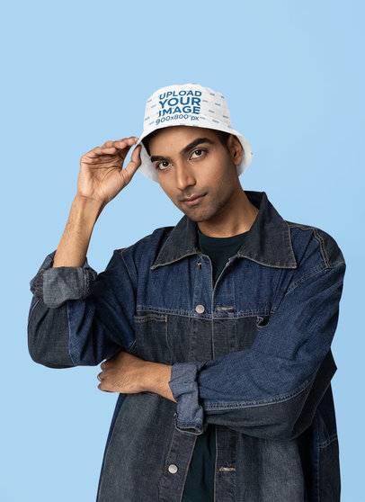 Mockup of a Man Wearing a Bucket Hat and Denim Garments in a Studio