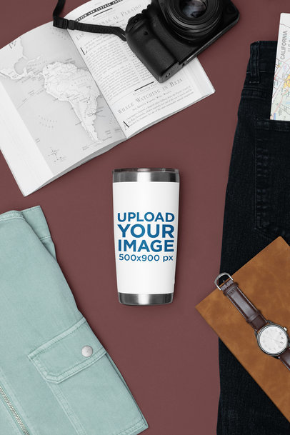 Mockup Featuring a Travel Mug Placed Next to an Open Book and a Camera m37467