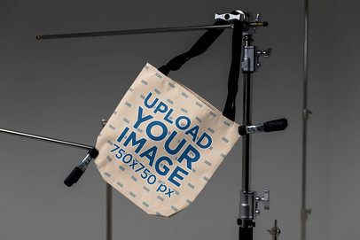 Mockup of a Sublimated Tote Bag Hanging From a Steel Tripod m37626