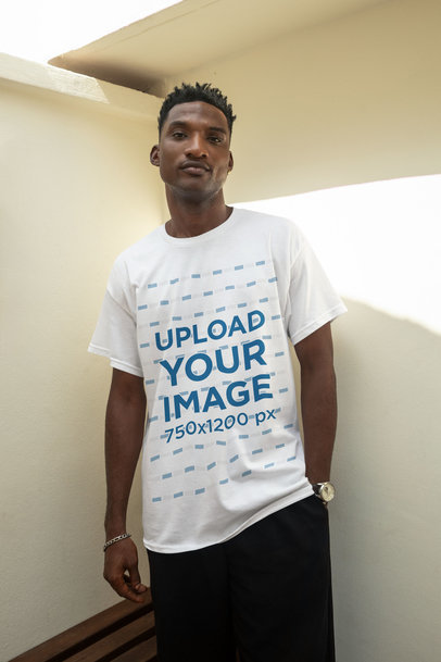 Round-Neck T-Shirt Mockup Featuring a Serious Man Posing Against a Wall