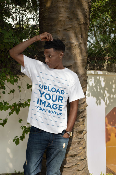 Round-Neck T-Shirt Mockup Featuring a Man Posing Against a Tree