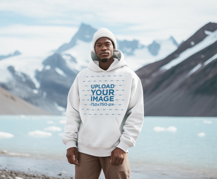 Mockup of a Man Wearing a Pullover Hoodie in Front of a Snowy Mountain for Earth Day