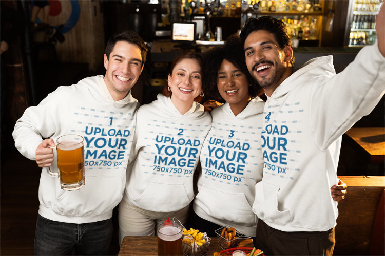 Mockup of Four Happy Friends Wearing Matching Gildan Hoodies at a Sports Bar