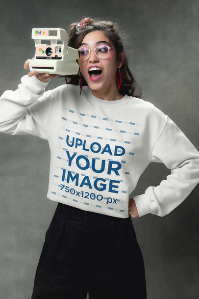 Gildan Sweatshirt Mockup of a Woman Taking a Picture with a Retro Instant Camera m36957