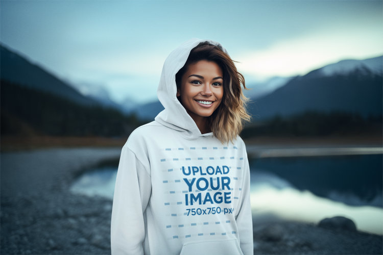 Earth Day-Themed Mockup of a Smiling Woman Wearing a Hoodie by a Lake at Night