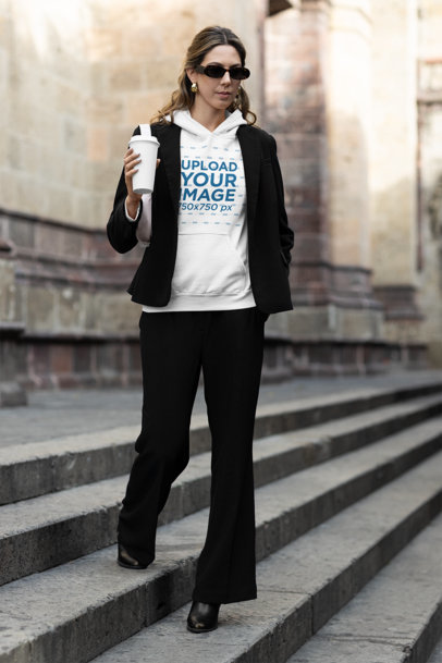 Gildan Hoodie Mockup Featuring a Woman Walking Near a Church in a Modest Outfit