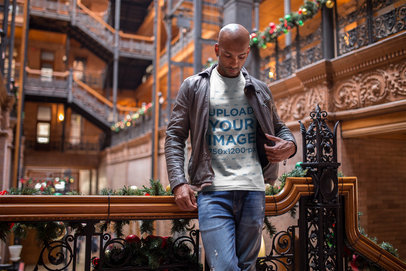 Mockup of a Black Man Wearing a T-Shirt and a Leather Jacket Inside a Historical Building During Christmas a18313