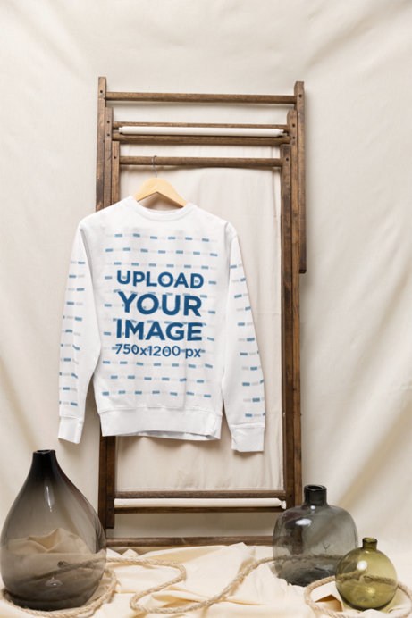 Mockup of a Cotton Heritage Crewneck Sweatshirt Hanging on a Rustic Setting