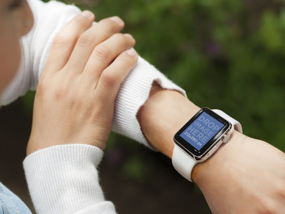 Busy Young Woman Using Her White Apple Watch Outdoors