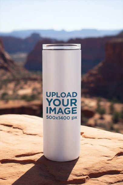 Mockup of a Skinny Tumbler Placed on a Rock at the Top of a Mountain