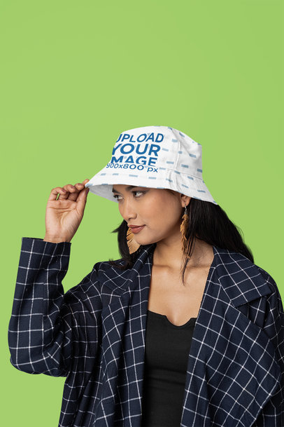Mockup of a Woman Wearing a Sublimated Bucket Hat in a Studio