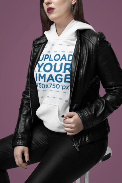 Mockup of a Woman Wearing a Gildan Hoodie Under a Rockstar-Inspired Leather Garment