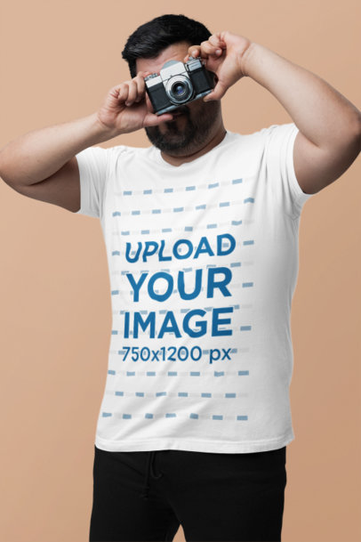 Bella Canvas T-Shirt Mockup Featuring a Bearded Man Taking a Picture With a Vintage Camera