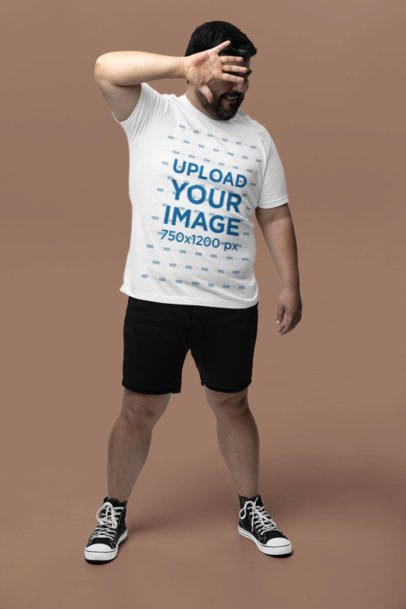 Bella Canvas Round-Neck Tee Mockup of a Bearded Man Covering His Face in a Studio