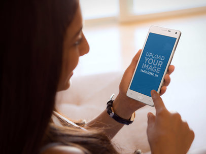 Mockup of a Young Woman Using Samsung Galaxy Note 4 at Home 