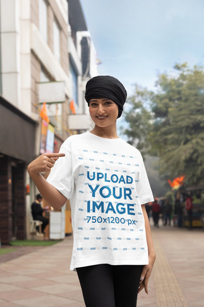 Mockup of a Happy Woman with a Turban Pointing at Her Blinkstore Crewneck Tee