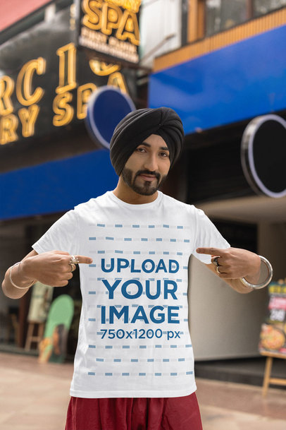 Mockup of a Man with a Turban Pointing at His Scott International T-Shirt 