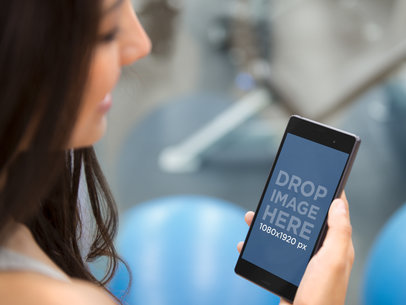 Young Athletic Woman Using Android Phone at the Gym