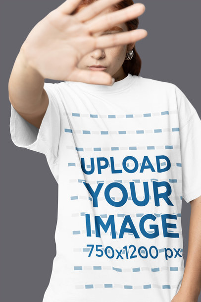 Mockup of a Woman Covering Her Face and Wearing an Oversized T-Shirt in a Studio