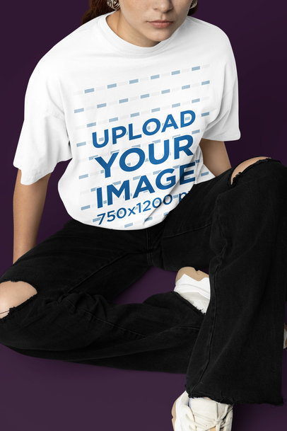 Mockup Featuring a Woman Wearing an Oversized T-Shirt While Sitting in a Studio
