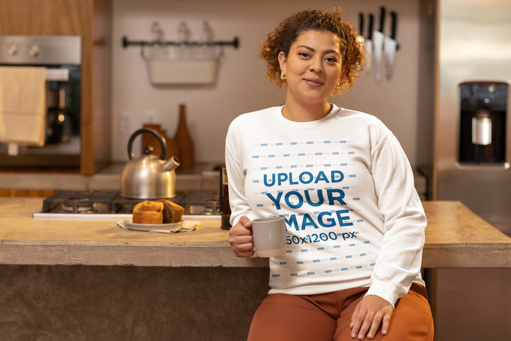 Gildan Sweatshirt Mockup of a Happy Woman Posing With a Cup of Coffee in a Kitchen