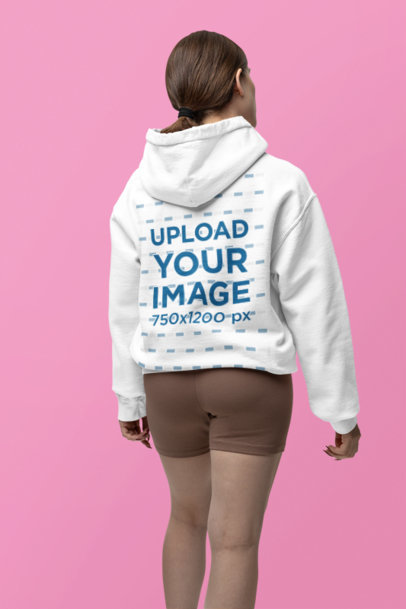 Back-View Gildan Hoodie Mockup of a Woman Posing in a Customizable Background