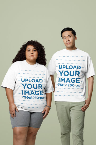 Oversized T-Shirt Mockup Featuring a Serious Man and Woman Standing in a Studio